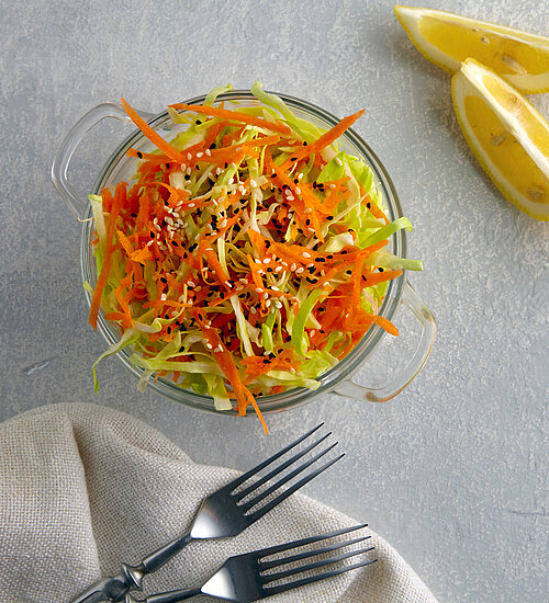 Vegetarian healthy salad of raw vegetables cabbage and carrots with sesame seeds.