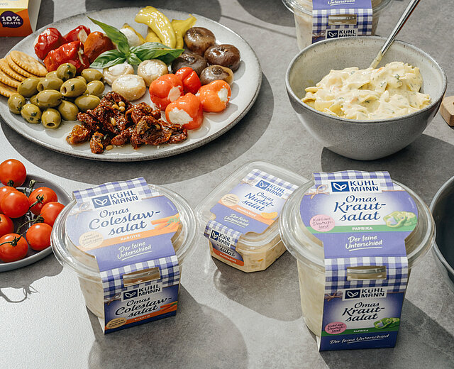 Angerichtete und verpackte Kühlmann Produkte auf einem Tisch.