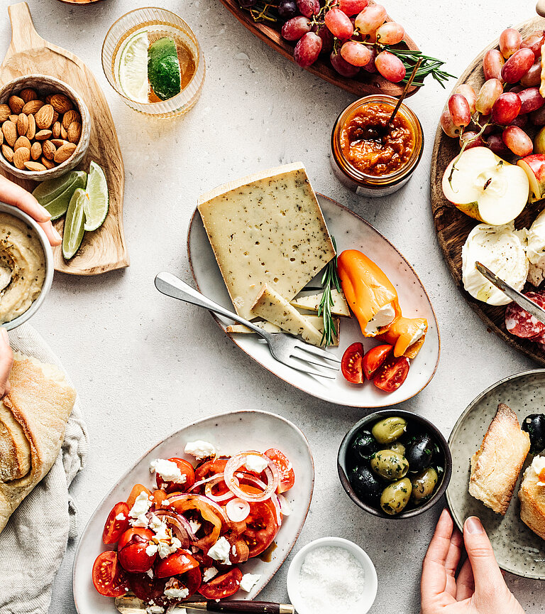 Frauenhände an einem Tisch mit mediterranen Produkten