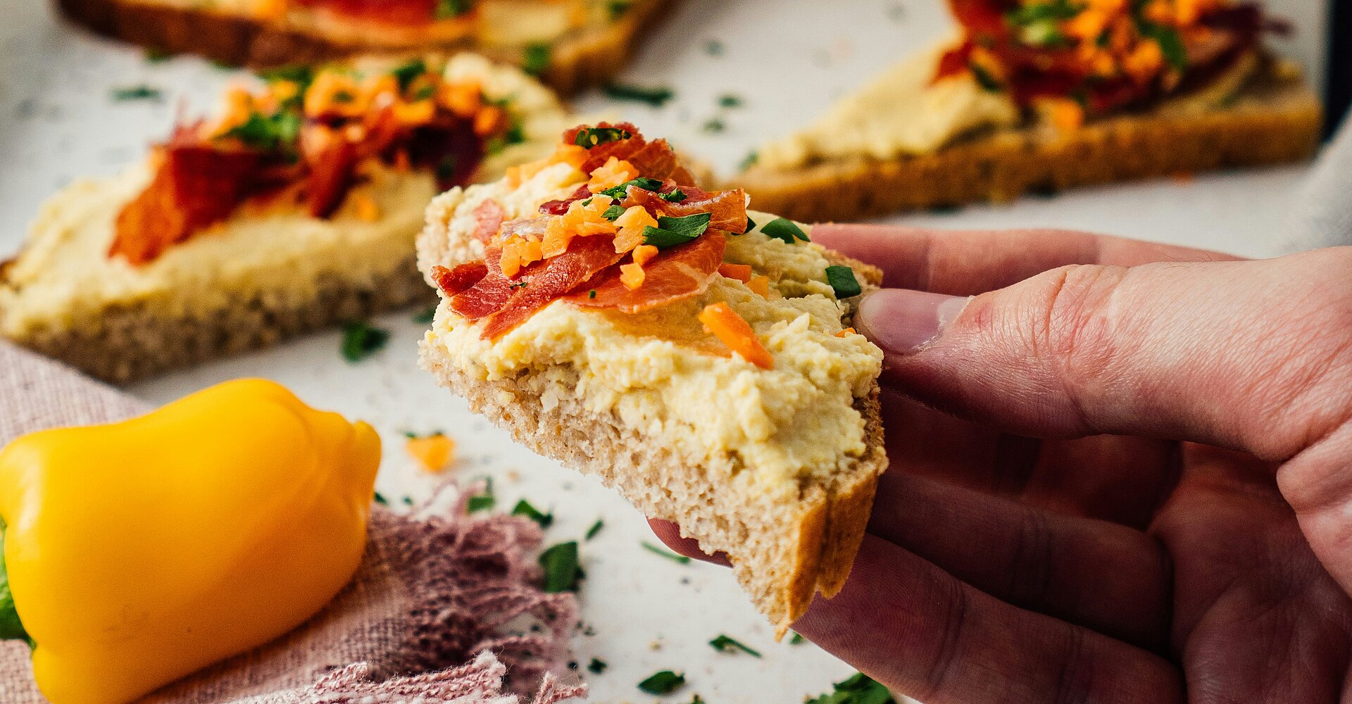 Geschnittenes Brot mit Käse und Tomaten auf weißer Keramikplatte