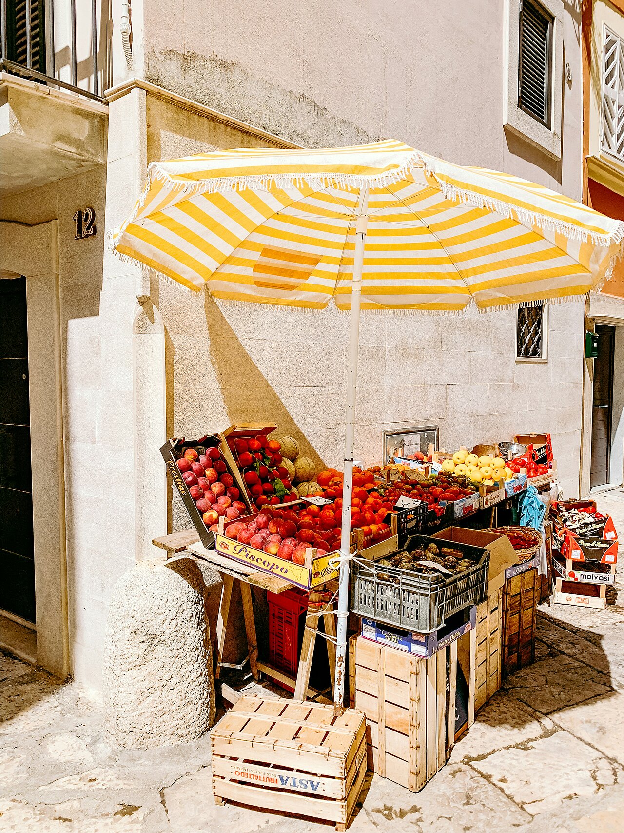 a yellow-and-white parasol and a few boxes of fruit