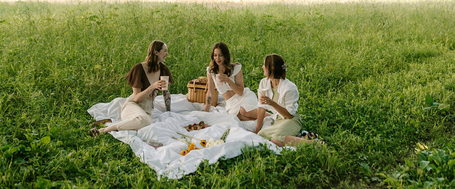 Eine Gruppe von Frauen, die auf einer üppigen grünen Wiese sitzen