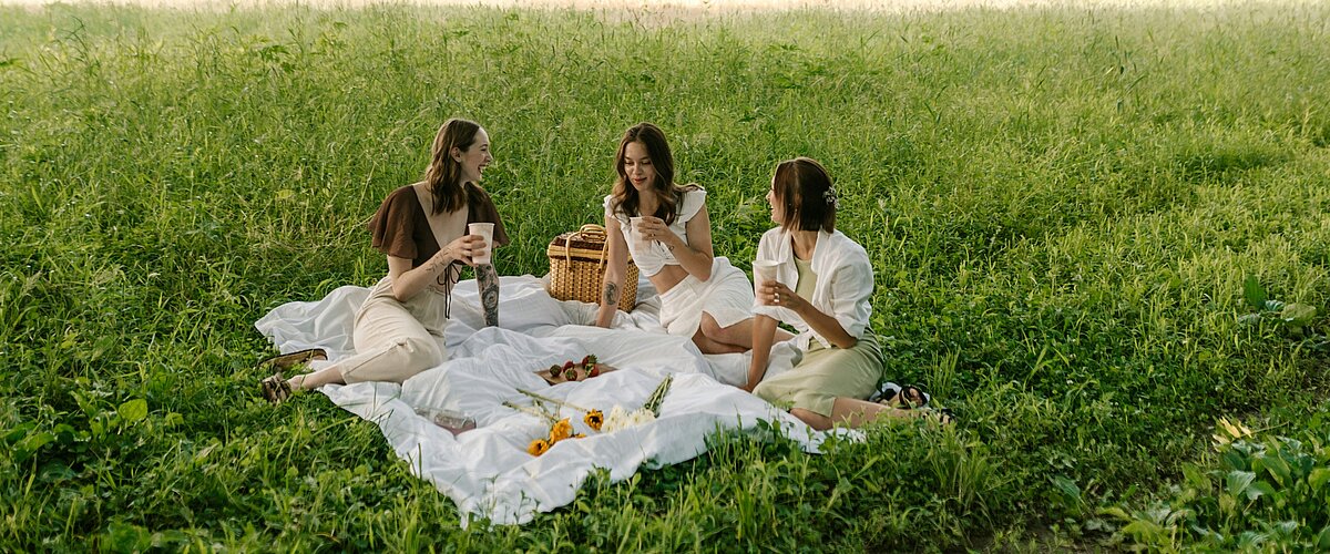 A group of women sitting on a lush green meadow