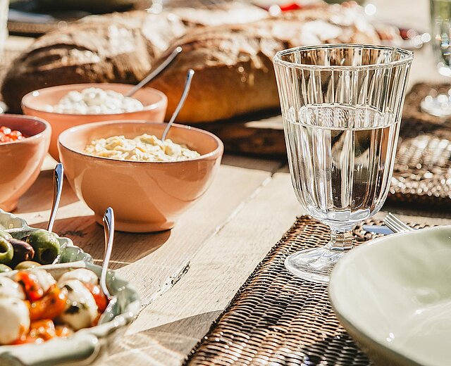 Ein Tisch mit Tellern mit Essen und Schüsseln mit Soßen 