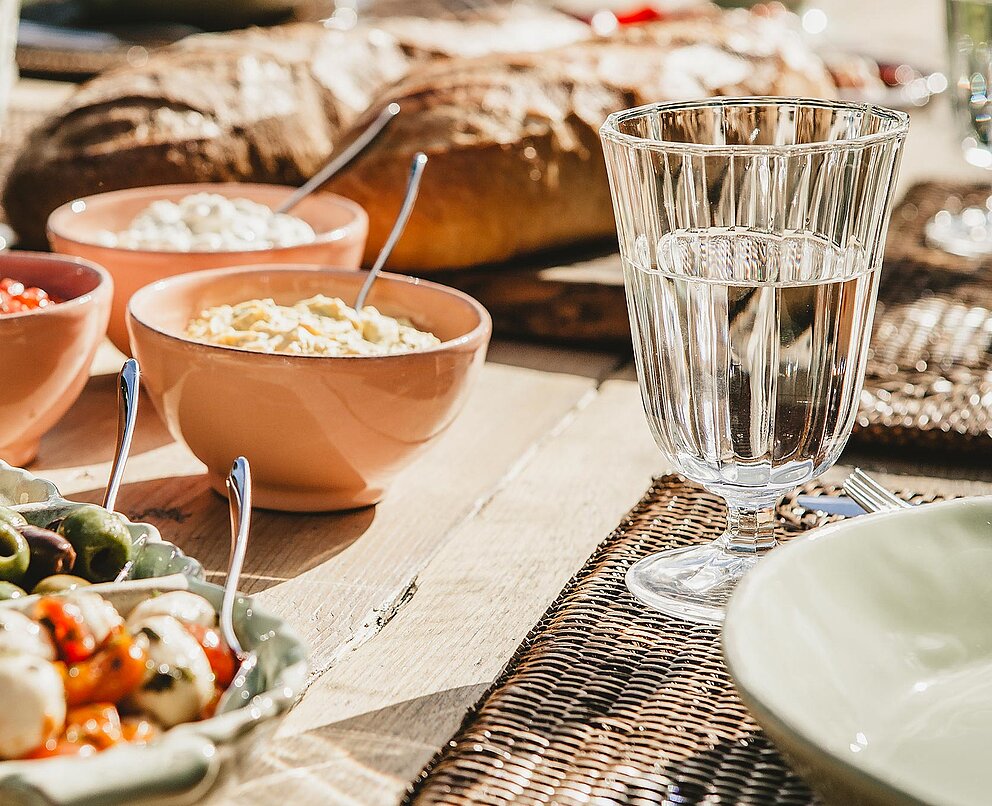 Ein Tisch mit Tellern mit Essen und Schüsseln mit Soßen 